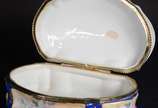 Caixa/porta jóias de porcelana francesa, decora... - Caixa/porta jóias de porcelana francesa, decorada com cena galante em policromia sobre fundo azul e guirlandas douradas, parte interna com flore...