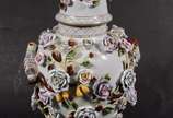 Potiche de porcelana europeia ricamente decorad... - Potiche de porcelana europeia ricamente decorada com flores e pássaros policromados em relevo, realces dourados. Tampa encimada por figura de pá...