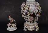 Potiche de porcelana europeia ricamente decorad... - Potiche de porcelana europeia ricamente decorada com flores e pássaros policromados em relevo, realces dourados. Tampa encimada por figura de pá...