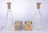 Par de garrafas de cristal facetado, bocais e s... - Par de garrafas de cristal facetado, bocais e suportes de metal com figuras de "caçador" em relevo (com desgastes, uma das tampas de diferente m...