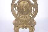 Cadeira de metal dourado trabalhado em relevo, ... - Cadeira de metal dourado trabalhado em relevo, encosto com medalhão decorado com figura de lenhador, assento com detalhes vazados.