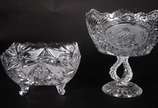 Duas fruteiras de cristal lapidado, sendo uma b... - Duas fruteiras de cristal lapidado, sendo uma baixa no feitio quadrangular e a outra de pé alto decorada com figuras de cisnes.