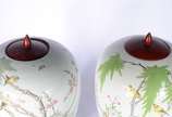 Par de antigos potiches de porcelana chinesa de... - Par de antigos potiches de porcelana chinesa decorados com galhos, folhagens e pássaros em policromia, tampas e bases de madeira.
