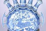 Peça decorativa de porcelana oriental decorada ... - Peça decorativa de porcelana oriental decorada com figura de animal estilizado e vegetação em tons de azul e branco, encimada por cinco pinos se...