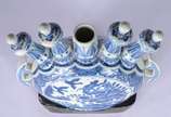 Peça decorativa de porcelana oriental decorada ... - Peça decorativa de porcelana oriental decorada com figura de animal estilizado e vegetação em tons de azul e branco, encimada por cinco pinos se...