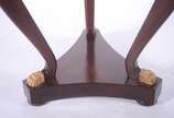 Mesa redonda de madeira nobre com 3 pernas recu... - Mesa redonda de madeira nobre com 3 pernas recurvas ligadas em platô inferior na forma triangular, pés de garras de bronze.<br><br>