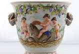 Vaso/cachepot  de porcelana alemã decorada com ... - Vaso/cachepot  de porcelana alemã decorada com figuras angelicais e cachos de uvas em relevo policromado ( pequeno lascado na base)