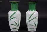 Par de vasos de porcelana branca pintados a mão... - Par de vasos de porcelana branca pintados a mão com folhagens  na cor verde. Altura 38 cm.