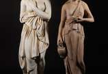Duas esculturas de cimento representando figura... - Duas esculturas de cimento representando figuras femininas. Com desgastes.