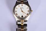 Bulova (1875),  - Relógio de pulso com caixa, pulseira, números e ponteiros em aço com dourado. No estojo, funcionando.