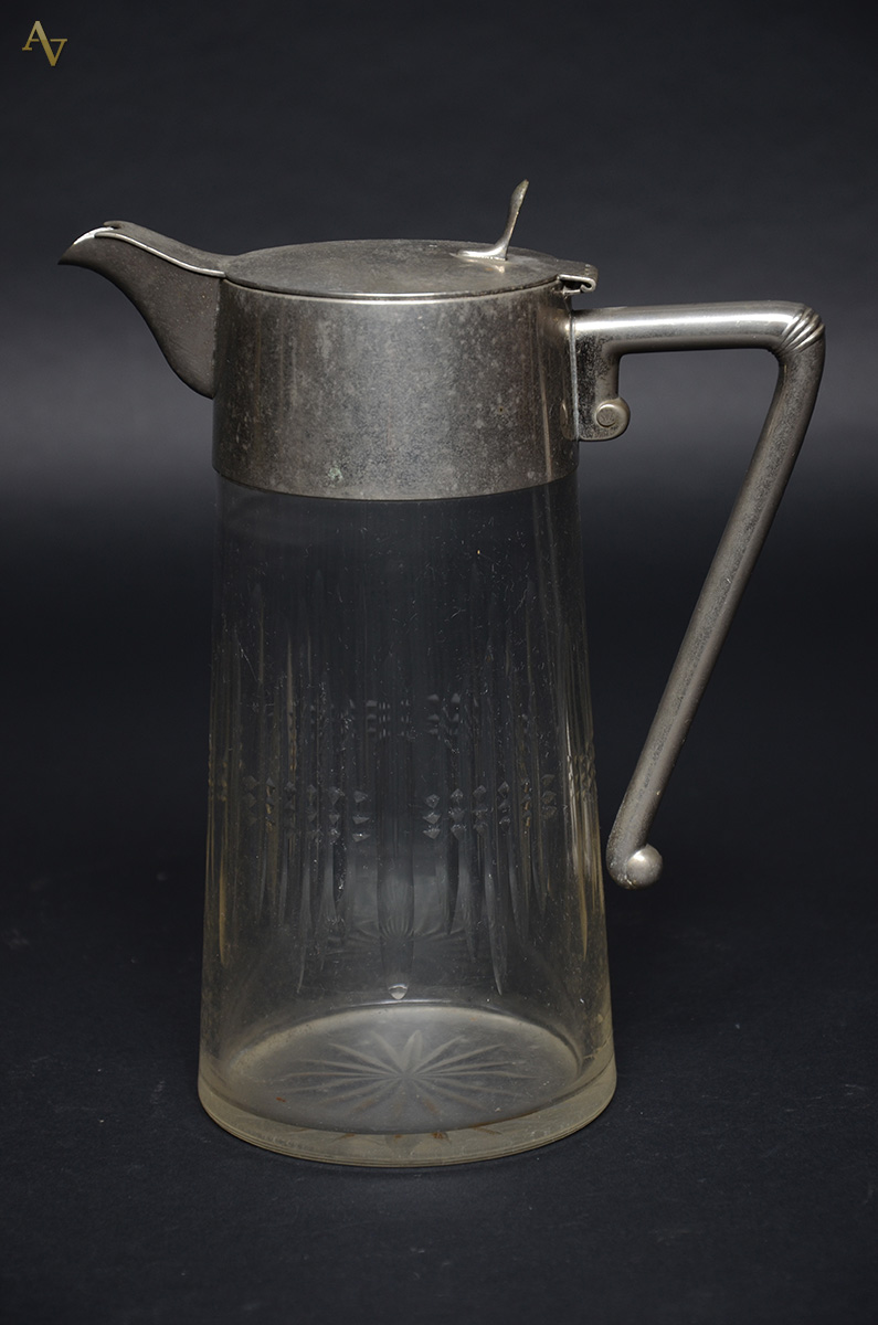 Refresqueira de cristal com alça e gargalo de metal. Altura 26,5 cm