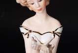 Estatueta de porcelana representando dama com b... - Estatueta de porcelana representando dama com borboleta.
