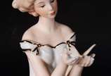 Estatueta de porcelana representando dama com b... - Estatueta de porcelana representando dama com borboleta.
