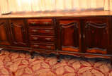 Buffet de jacarandá com 4 gavetas centrais e du... - Buffet de jacarandá com 4 gavetas centrais e duas portas almofadadas de cada lado, saia com florões entalhados, tampo recoberto por vidro .