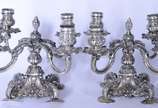 Par de candelabros de prata contrastada para 4 ... - Par de candelabros de prata contrastada para 4 velas cada, concheados e folhagens em relevo. Um deles quebrado. Peso da prata: 3040 g.  (Por mot...