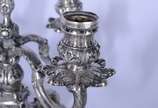 Par de candelabros de prata contrastada para 4 ... - Par de candelabros de prata contrastada para 4 velas cada, concheados e folhagens em relevo. Um deles quebrado. Peso da prata: 3040 g.  (Por mot...