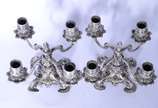 Par de candelabros de prata contrastada para 4 ... - Par de candelabros de prata contrastada para 4 velas cada, concheados e folhagens em relevo. Um deles quebrado. Peso da prata: 3040 g.  (Por mot...