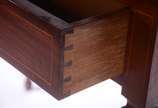 Mesa para escrita de madeira nobre filetada, ga... - Mesa para escrita de madeira nobre filetada, gaveta com puxadores de metal dourado, pernas retas. Alçada recortada com pequena prateleira. Estil...