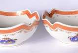 Par de bowls de porcelana com bordas recortadas... - Par de bowls de porcelana com bordas recortadas, tarjas na cor coral com guirlandas realçadas em dourado e brazões em policromia.