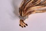 Broche de ouro 18 k., contraste 750 mls feitio ... - Broche de ouro 18 k., contraste 750 mls feitio sete folhas e um laço com brilhantes.  (Por motivos de segurança a peça não se encontra na loja).