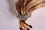 Broche de ouro 18 k., contraste 750 mls feitio ... - Broche de ouro 18 k., contraste 750 mls feitio sete folhas e um laço com brilhantes.  (Por motivos de segurança a peça não se encontra na loja).