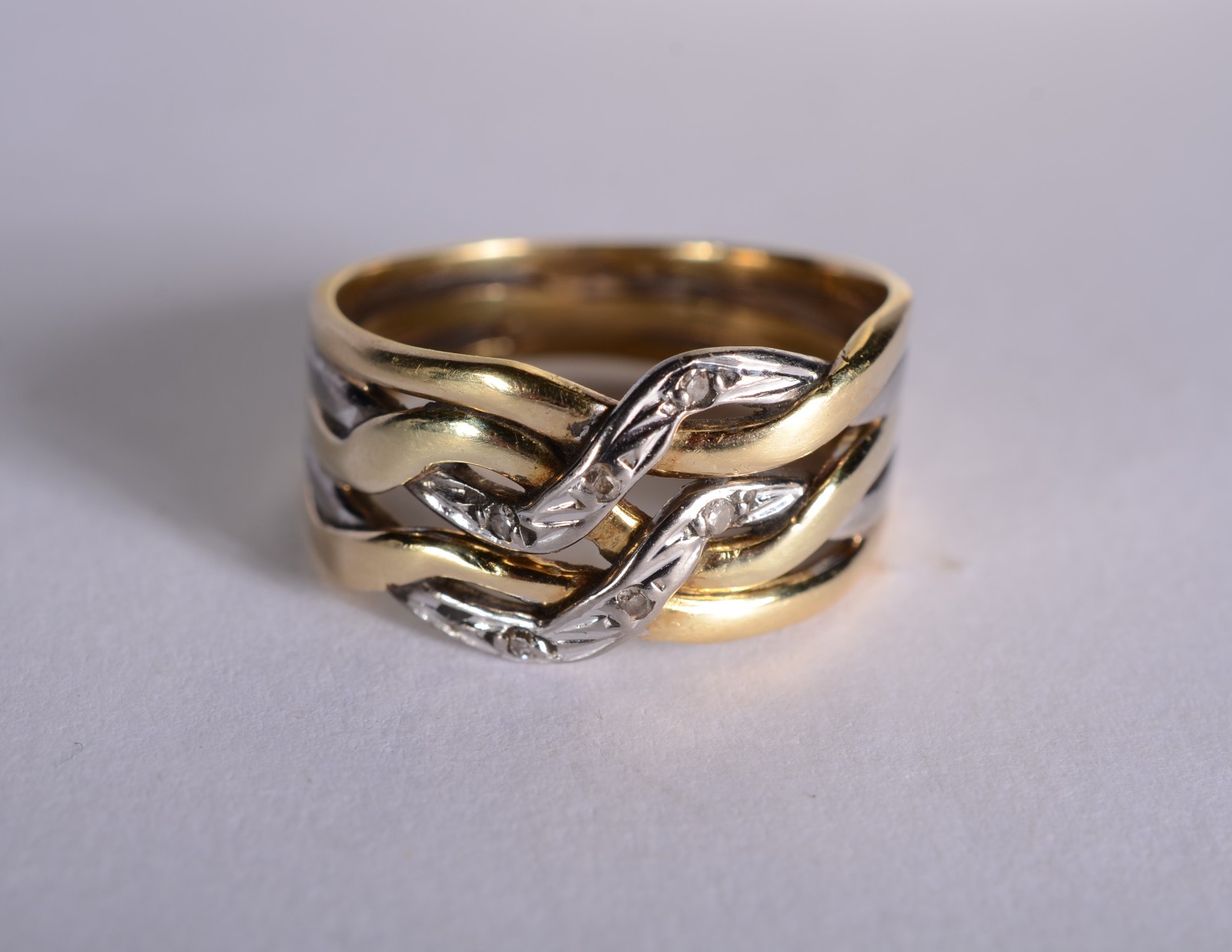 Anel de ouro 18 k., e ouro branco entrelaçados cravejado com... - foto 1 de 5