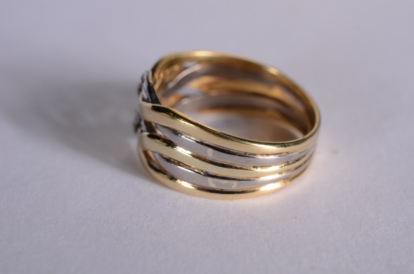 Anel de ouro 18 k., e ouro branco entrelaçados cravejado com... - foto 2 de 5