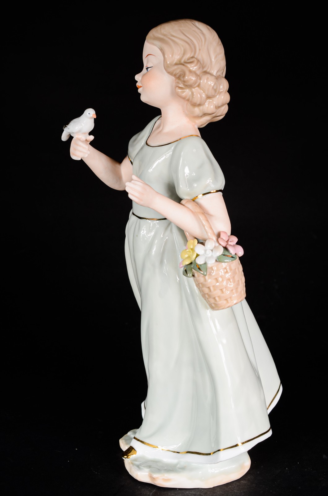 Estatueta de porcelana policromada representando menina com pomba na... - foto 2 de 6