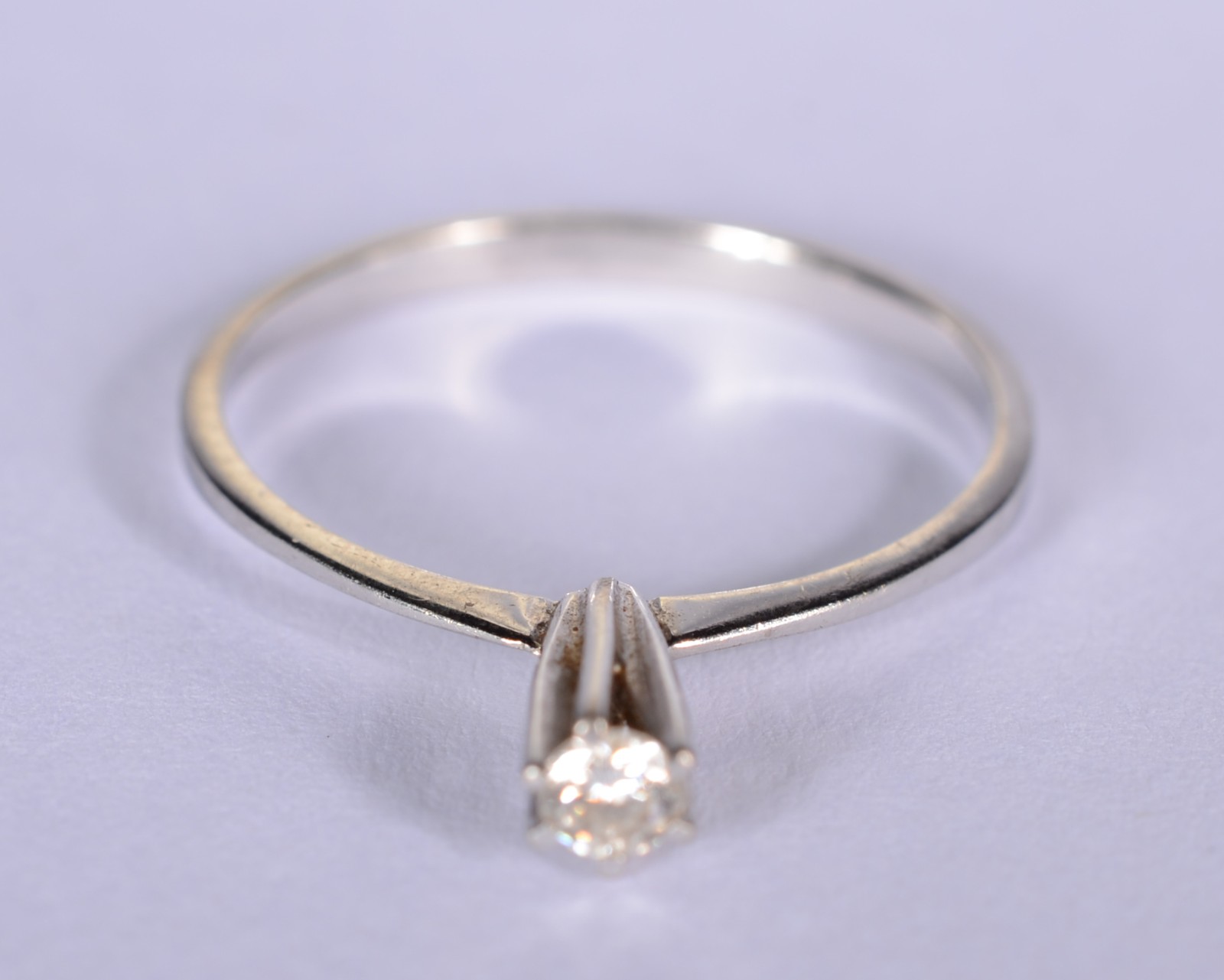 Solitário de ouro branco com um brilhante de 0,10 ct, aro 15. (Por... - foto 1 de 5