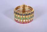 Anel de ouro 18 k., com 5 alianças com rubi, br... - Anel de ouro 18 k., com 5 alianças com rubi, brilhantes, esmeraldas e safiras azuis, aro 17. (Por motivos de segurança a peça não se encontra na...