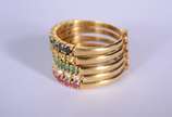 Anel de ouro 18 k., com 5 alianças com rubi, br... - Anel de ouro 18 k., com 5 alianças com rubi, brilhantes, esmeraldas e safiras azuis, aro 17. (Por motivos de segurança a peça não se encontra na...