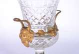 Ânfora de cristal europeu lapidado, guarnição d... - Ânfora de cristal europeu lapidado, guarnição de metal dourado decorado com figuras de Baco, folhas de parreiras e cachos de uvas.