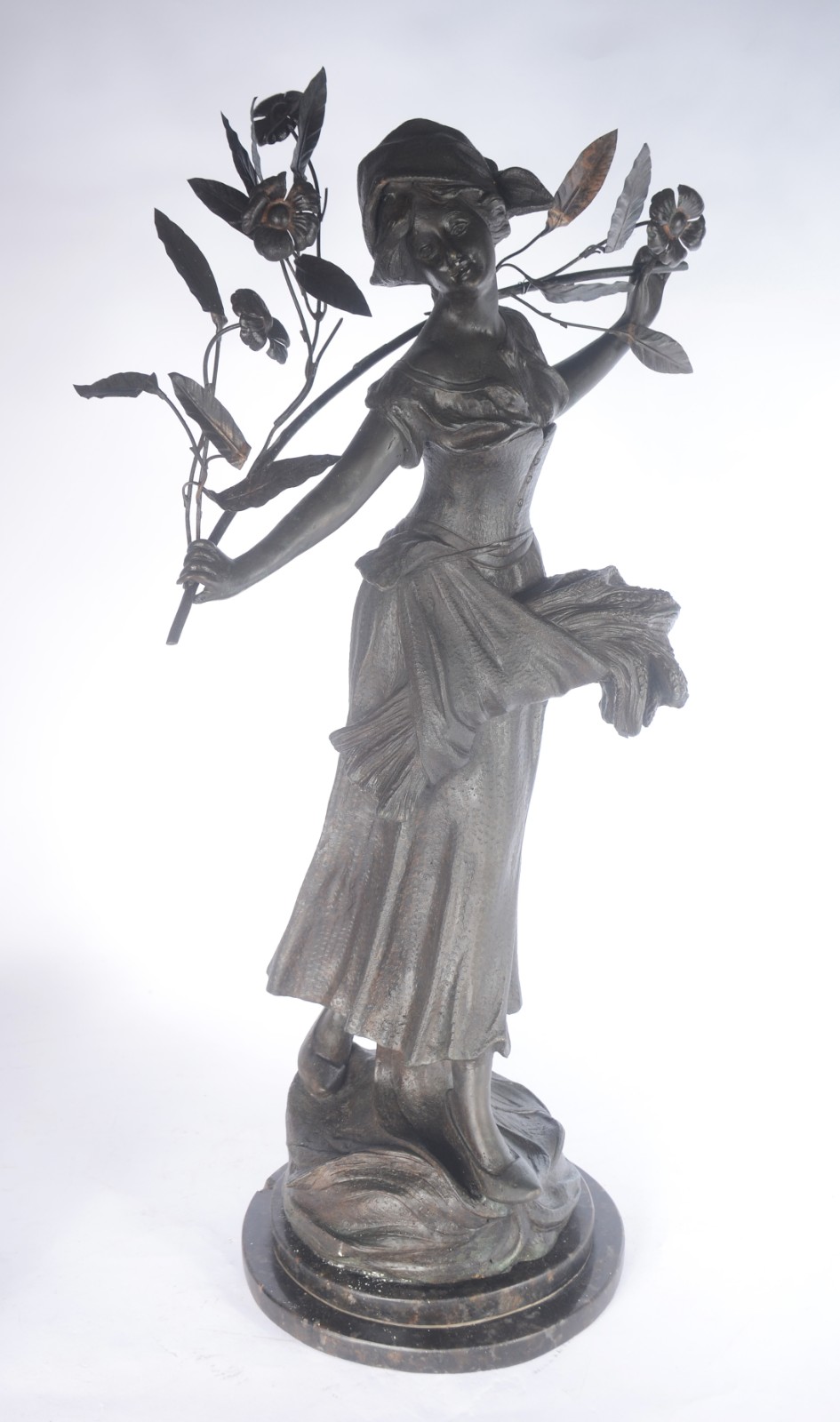 Escultura de metal representando figura feminina segurando ramo de... - foto 1 de 5