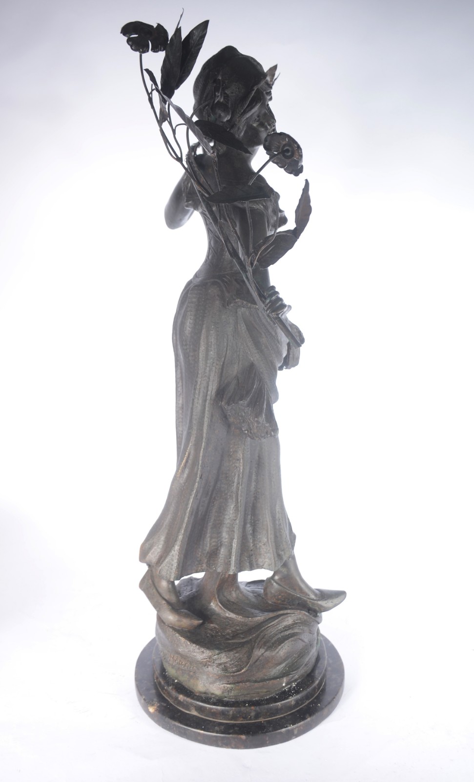 Escultura de metal representando figura feminina segurando ramo de... - foto 2 de 5