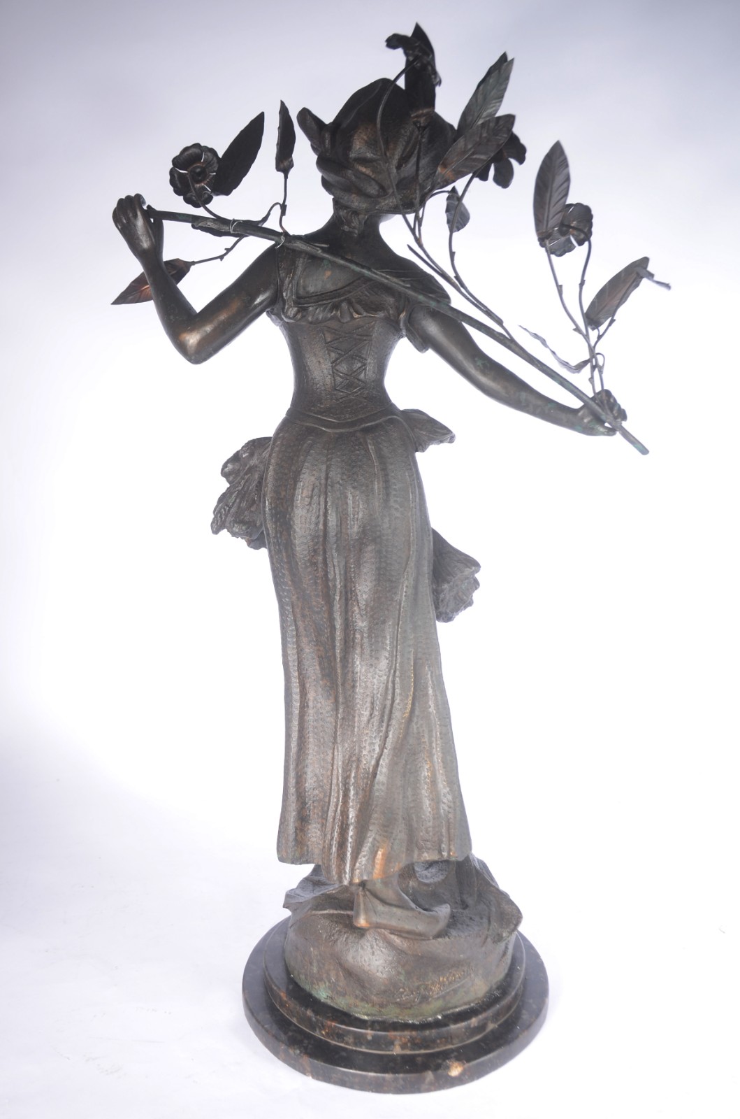 Escultura de metal representando figura feminina segurando ramo de... - foto 3 de 5