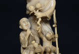 Escultura de marfim representando dois homens c... - Escultura de marfim representando dois homens com criança e macaco. Altura total 19 cm.