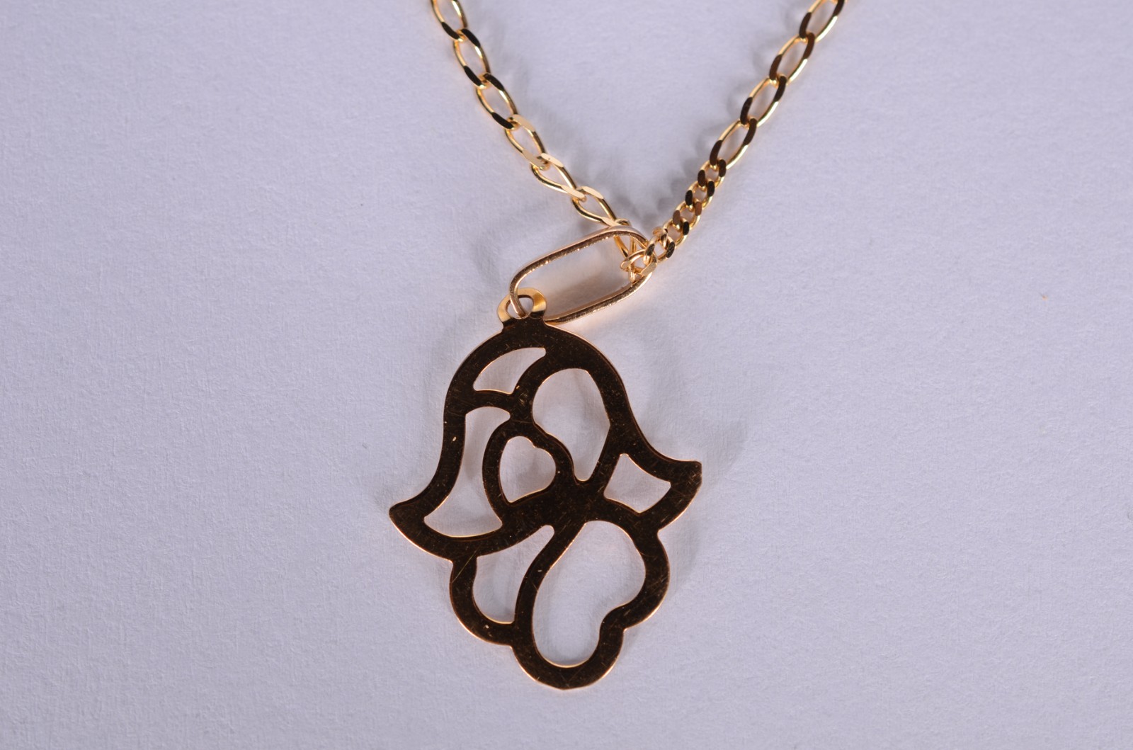 Colar com pendente na forma de mão de Hamsa de ouro 18 k., contraste... - foto 1 de 6
