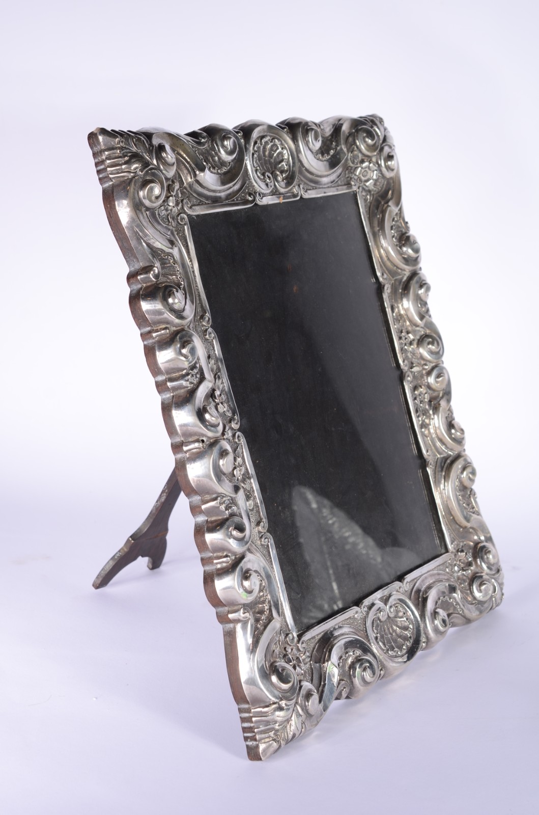 Porta retrato de madeira com moldura de prata decorada com concheados. - foto 1 de 8