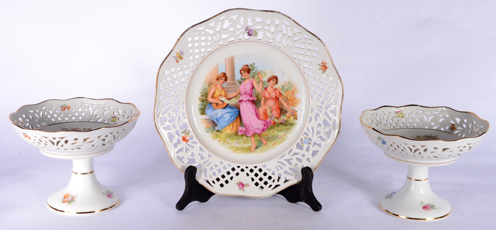 Três peças de porcelana, sendo duas fruteiras de pé alto com bordas... - foto 1 de 11