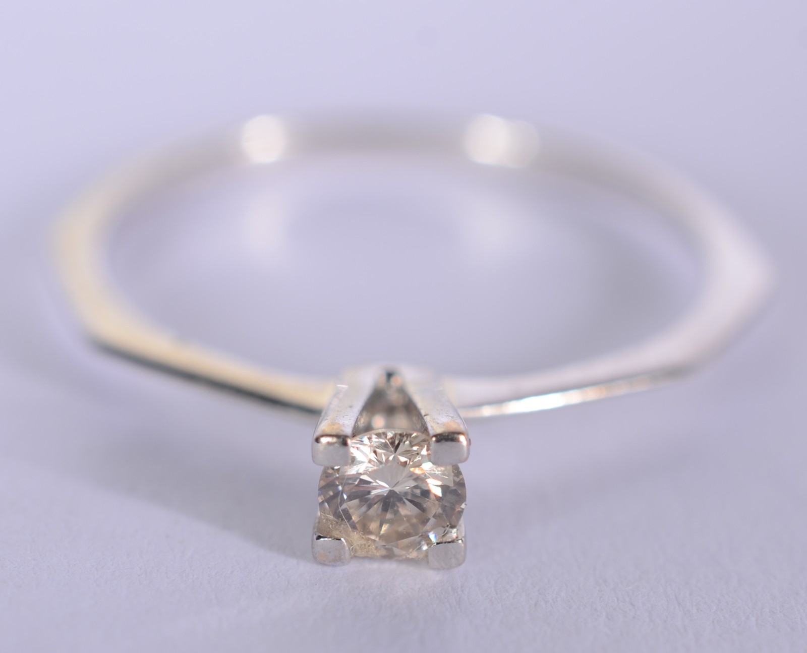 Solitário de ouro branco com um brilhante de 0,20 ct, aro 18. (Por... - foto 1 de 6