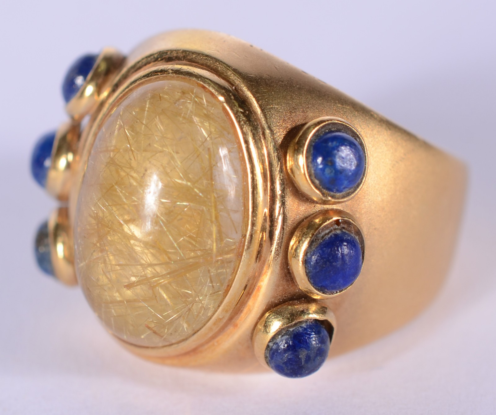 Anel de ouro 18 k., pedra cabochon clara e pedras azuis laterais, aro... - foto 1 de 5