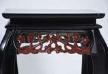 Duas colunas orientais de madeira pintada de pr... - Duas colunas orientais de madeira pintada de preto, saias com entalhes florais na cor rouge de fer, tampos quadrangulares sobre quatro pernas re...