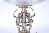 REED & BARTON,  - Fruteira com base de metal prateado Reed&Barton com figuras de anjos com lenços, pés de garra, prato de cristal.