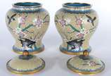 Par de potiches de cloisonné oriental decorados... - Par de potiches de cloisonné oriental decorados com flores e pássaros em policromia sobre fundo amarelo, bases de madeira.