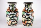 Par de vasos de porcelana oriental, decorado co... - Par de vasos de porcelana oriental, decorado com flores, folhas e pássaros em policromia sobre fundo preto.