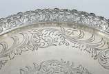 Salva de prata contrastada, fundo cinzelado, ga... - Salva de prata contrastada, fundo cinzelado, galeria vazada com concheados e flores. Peso da prata: 540 g. (Por motivos de segurança a peça não ...
