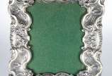 Grande porta retrato com moldura de prata de le... - Grande porta retrato com moldura de prata de lei decorado com concheados em relevo. Peso da prata: 500 g. (Por motivos de segurança a peça não s...