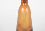 Garrafa de vidro na cor caramelo com mesclas es... - Garrafa de vidro na cor caramelo com mesclas escuras, assinada. Pequeno lascado na parte interna da tampa.