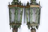 Par de lanternas de procissão de madeira entalh... - Par de lanternas de procissão de madeira entalhada e patinada de verde com resquícios dourados, encimadas por pinos torneados.