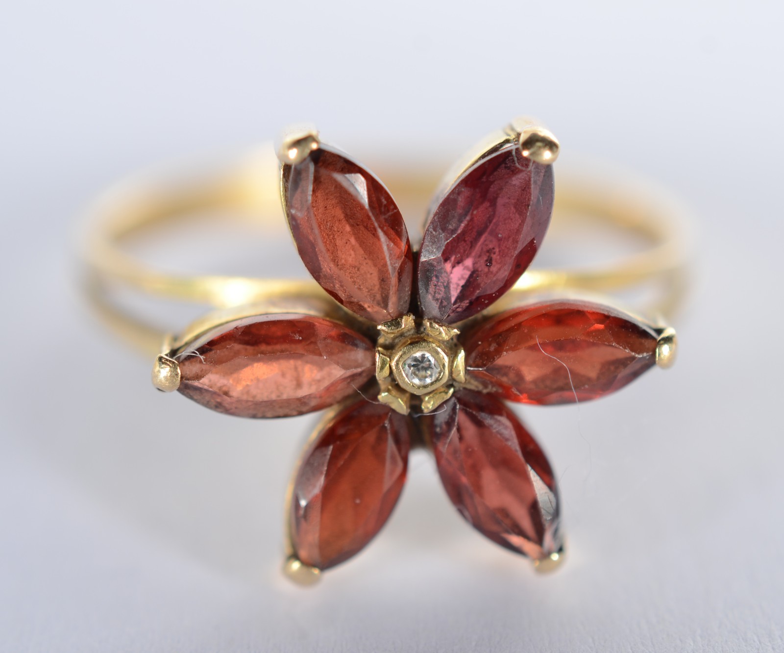 Anel de ouro 18 k., contraste 750 mls feitio flor com pedras e um... - foto 1 de 4